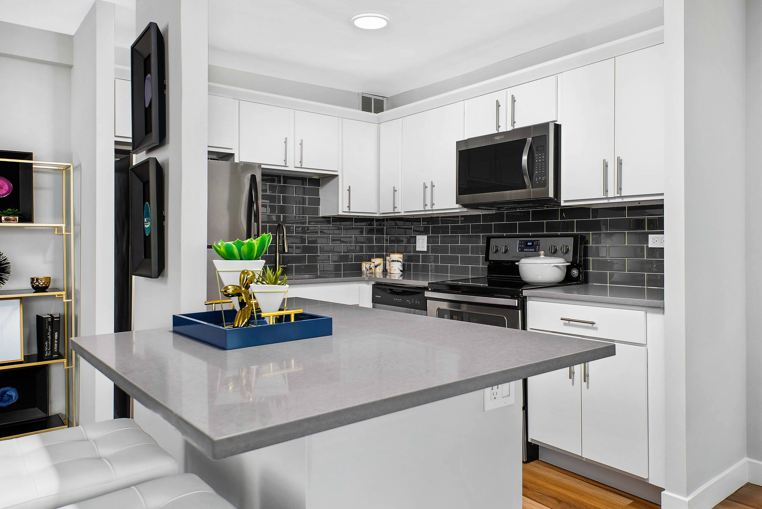 Modern kitchen with white cabinets and gray subway tile backsplash 