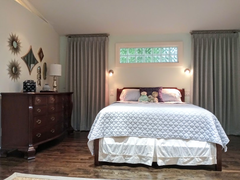 We are loving the collection of mirrors over the dresser in this bedroom. With our matching floor to ceiling drapery framing the bed this guest room is raised to a new level of glamorous! By raising the drapes all the way to the ceiling we bring additional height and dramatic effect to the room.