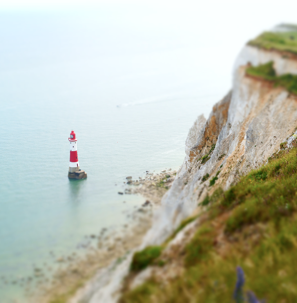 Aerial view of a lighthouse in a calm body of water.