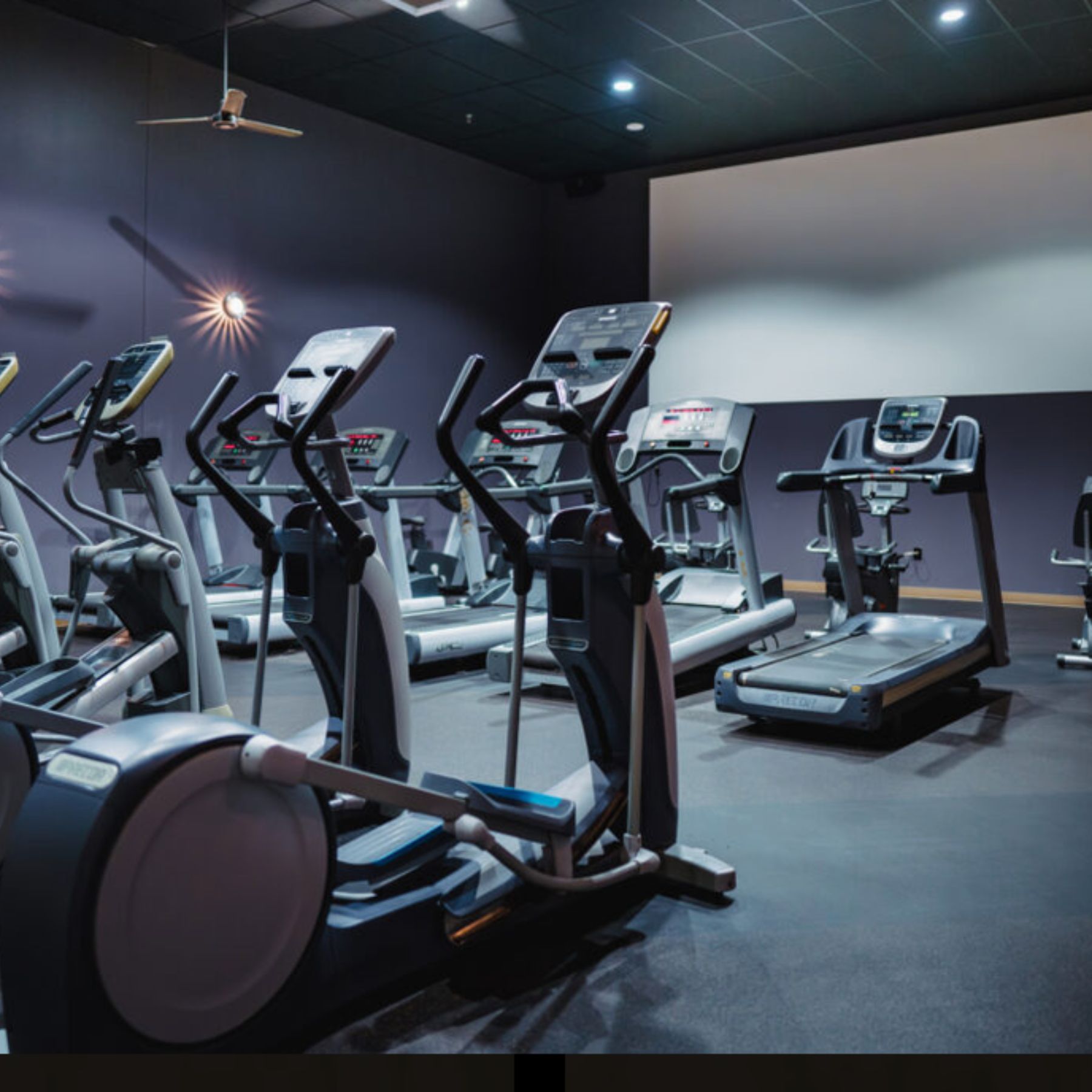 The Cardio Cinema at our Cheyenne gym features treadmills, ellipticals, and other cardio machines arranged in front of a large projection screen. The dimly lit space creates an immersive environment where members can stay entertained while getting in their cardio workout.