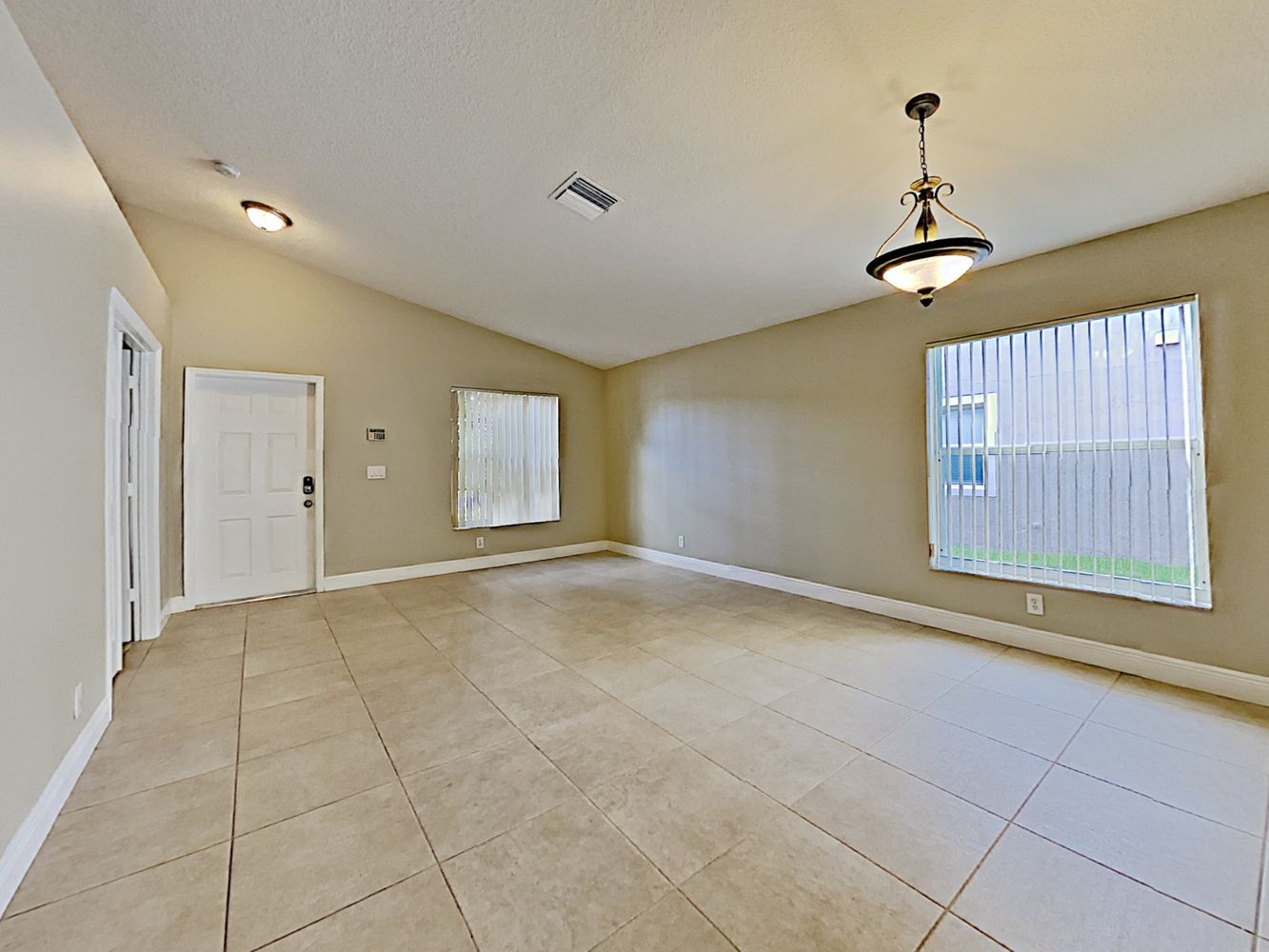 Charming living space with beautiful tile flooring and a dining area at Invitation Homes South Florida.