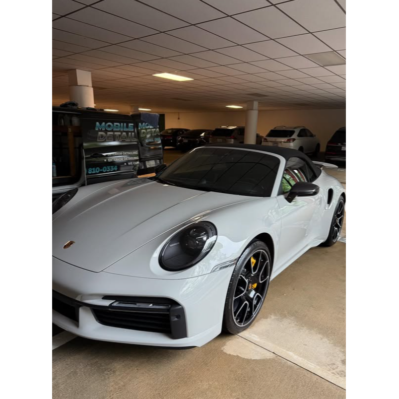 Clean white Porsche 911 after professional exterior detailing, with a glossy finish, spotless wheels 