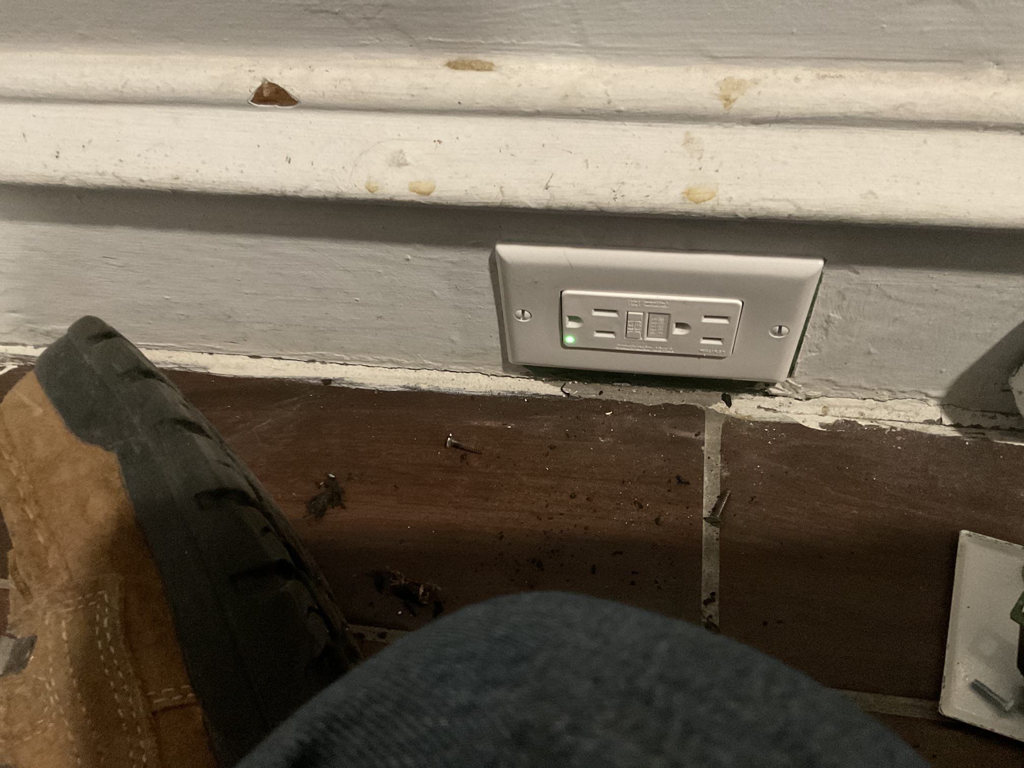 Thomas Edison Electric installed a GFCI outlet along the baseboard of a Philadelphia, PA home near Cottman Ave. The green indicator light confirms the outlet is properly wired and providing ground-fault protection.