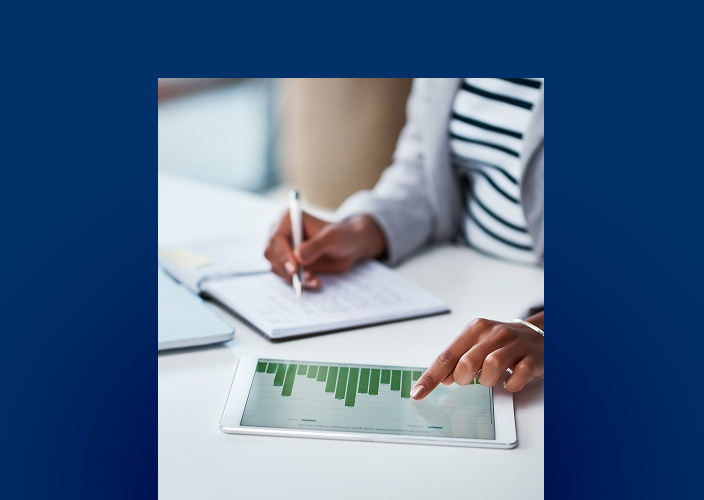 Close-up of an individual reviewing their finances at their desk.