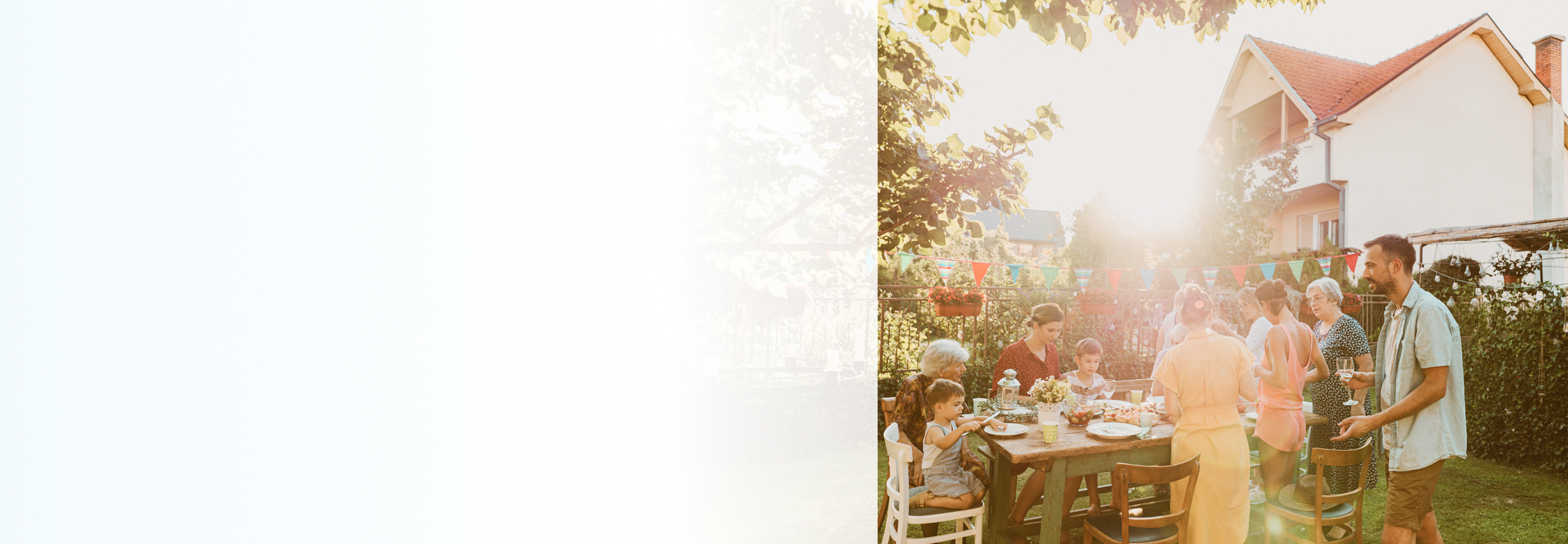 A multigenerational family sharing a meal in their backyard.