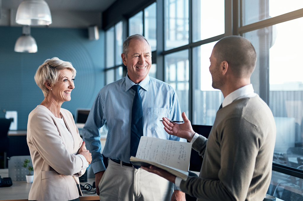 An advisor meeting with clients in an office setting.