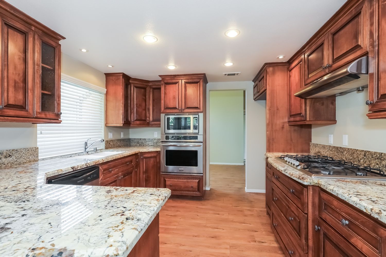 Kitchen with stainless steel appliances and granite countertops at Invitation Homes Pasadena.