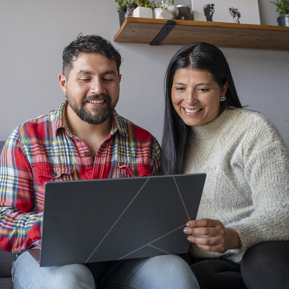 A man and woman looking at a laptop.