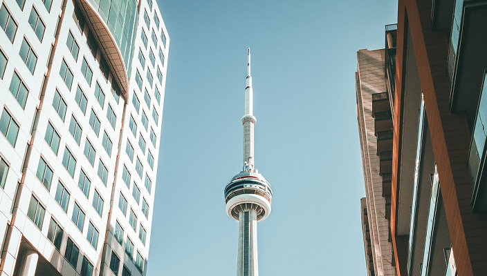 View of the CN Tower from between two buildings.