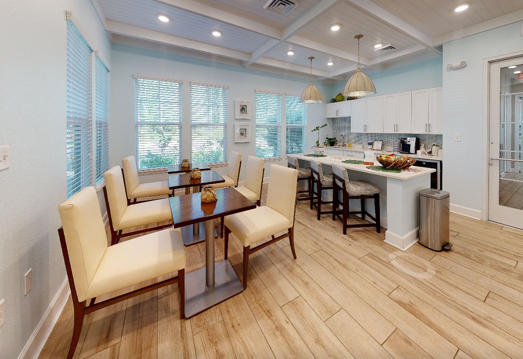 A spacious community dining area with caf&eacute;-style seating and a modern shared kitchen.