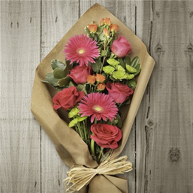Eden's Garden Handwrapped Bouquet Bright and vivacious colors make this incredible bouquet impossible to ignore and certain to be cherished. A vibrant combination of gerbera daisies, multi-color roses, athos and pittosporum are all wrapped up in craft paper, accented by a raffia tie.