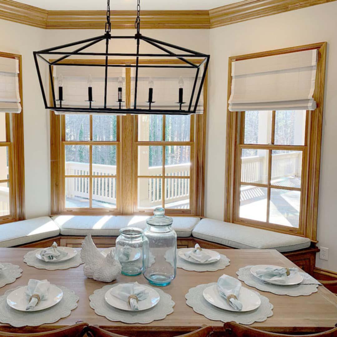 Create a softer look and feel to your dining room by adding Roman shades. This setup provides plenty of coverage across this nook allowing this customer to block out the light when they need to.