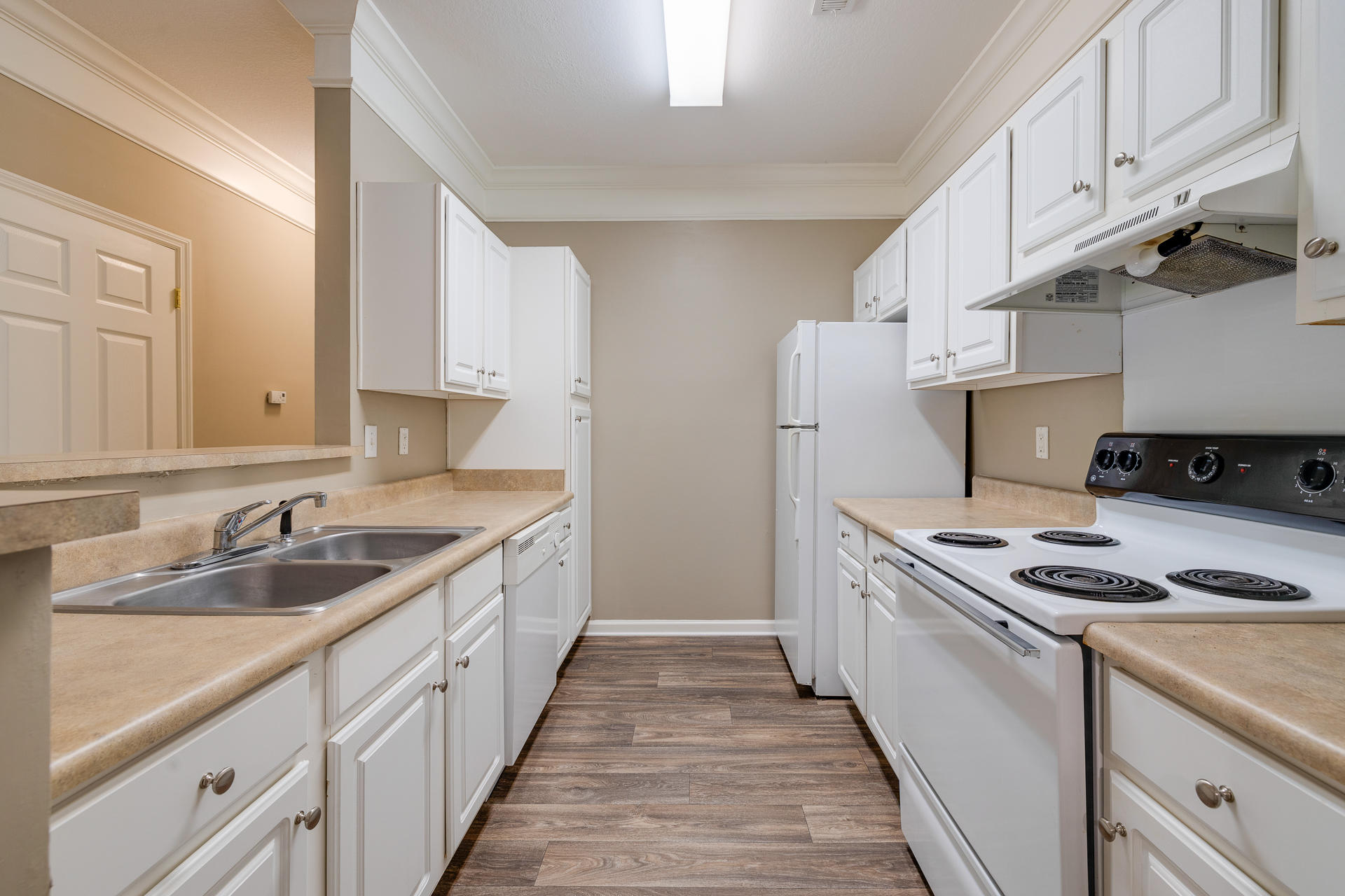 Galley Kitchen With White Cabinetry & Appliances