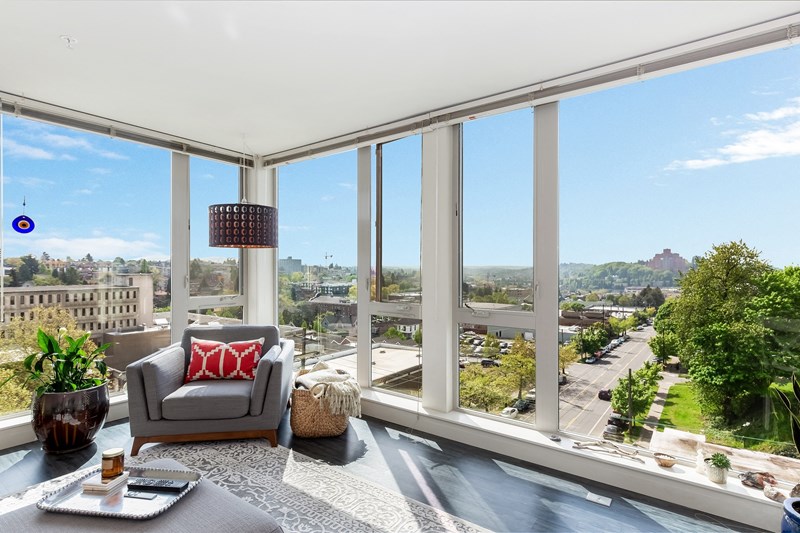 Living room with floor to ceiling windows at Decibel on 12th in Seattle, WA