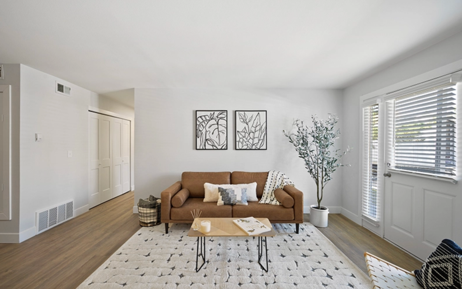 Open concept living room with hardwood floors and natural lighting.