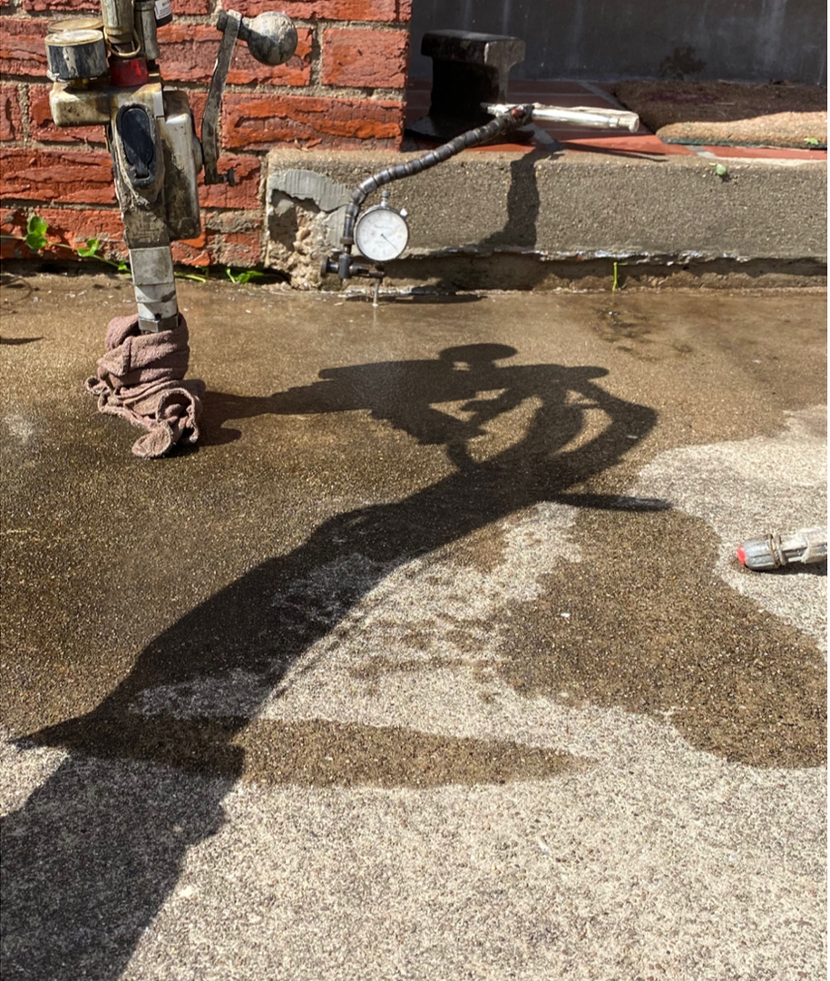 Concrete surface undergoing pressure and moisture testing using professional inspection equipment near a residential foundation area. The process ensures structural durability, proper surface performance, and accurate evaluation for repair, restoration, or construction maintenance services.