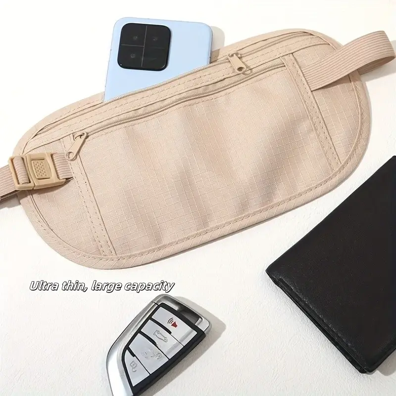 A beige fanny pack is shown on a white surface, with a light blue smartphone peeking out of the top pocket. A black wallet and a car key fob are placed next to the fanny pack. The text 'Ultra thin, large capacity' is overlaid on the image.