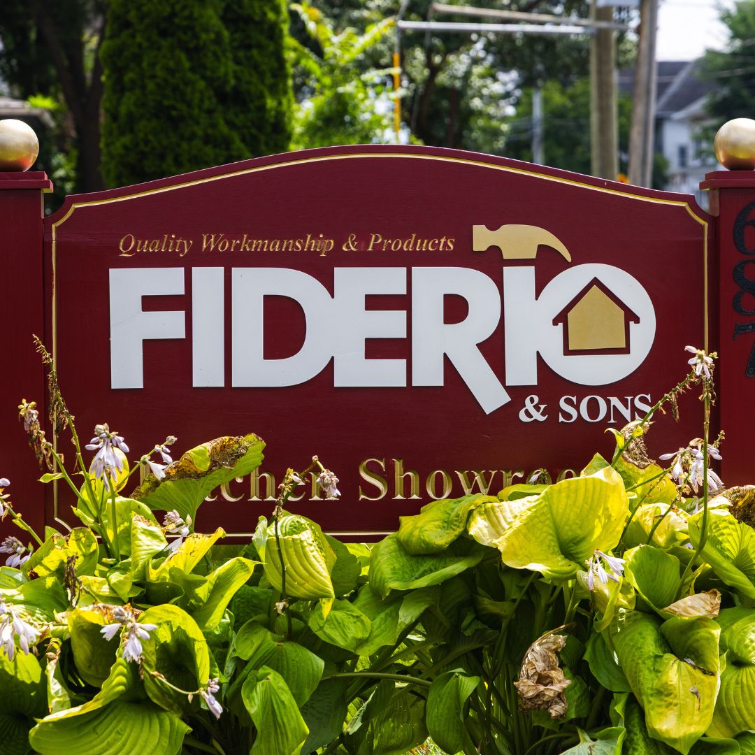 Close-up of the Fiderio & Sons logo carved into a red wooden sign: “Quality Workmanship & Products.”