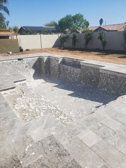 Pool renovation in progress with the existing swimming pool drained and interior materials removed i 