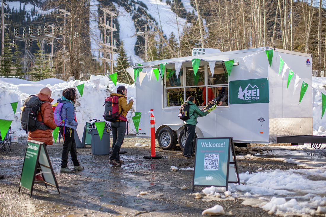 Snowshoe rental guests in line at REI rental trailer at Snoqualmie Pass