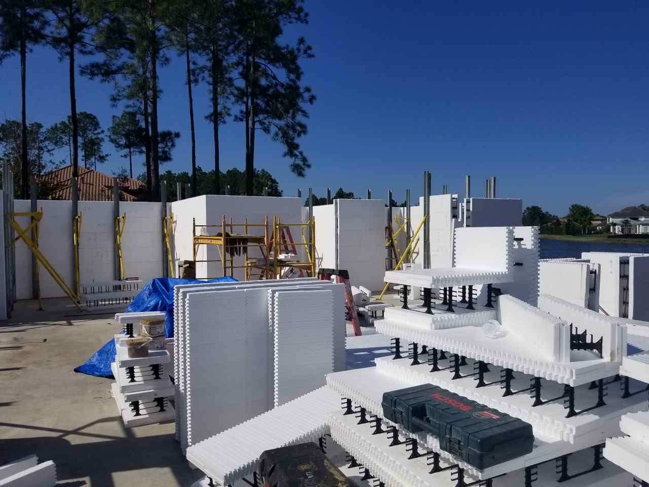 A construction site with white ICF (Insulated Concrete Forms) blocks stacked and assembled into wall 