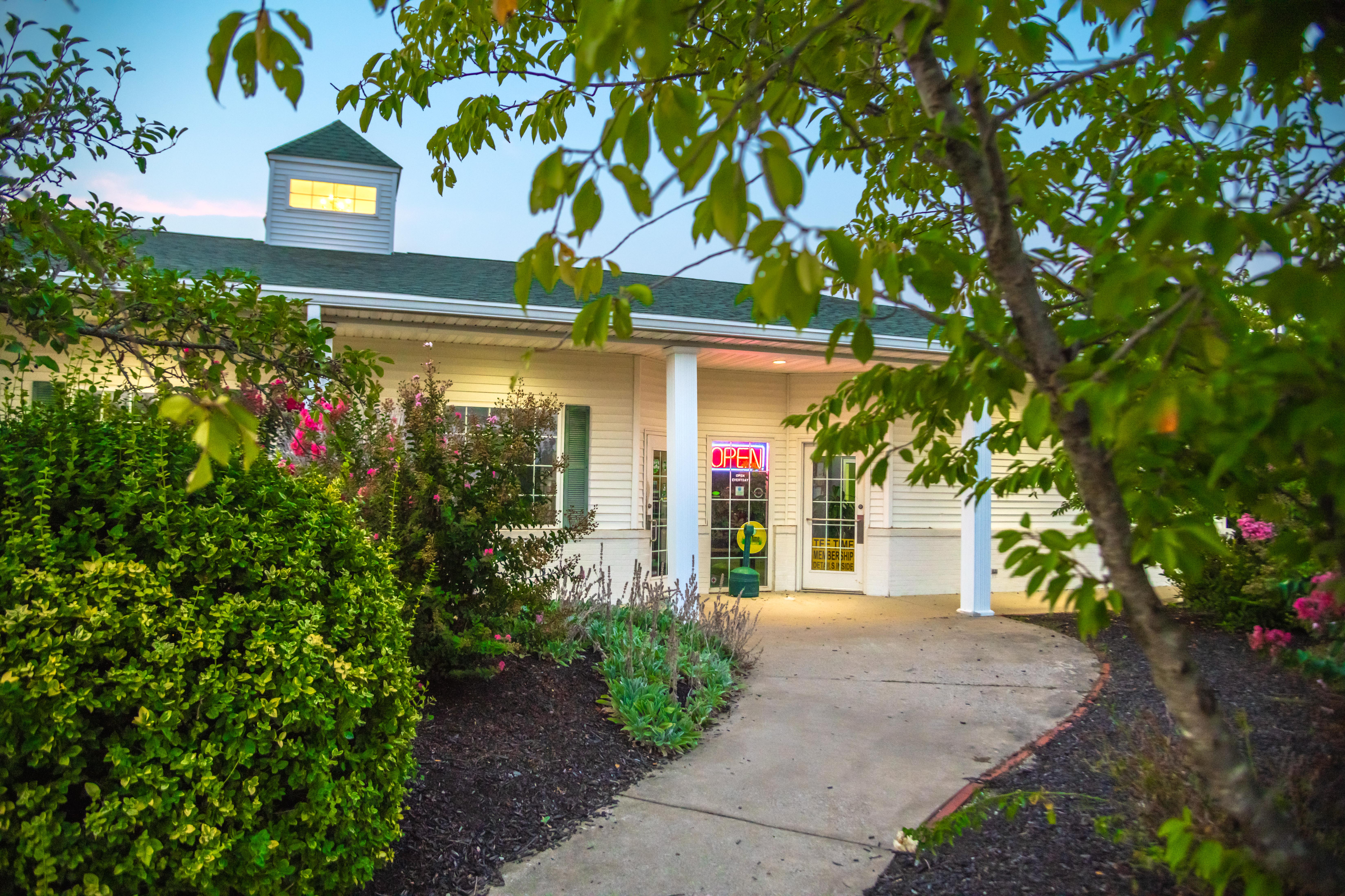 Welcome to Tee Time Golf Complex in Evansville, IN, featuring a landscaped entrance to the facility and its golf-focused services.