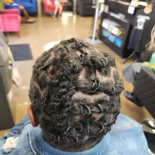 Top view showcasing artistic loc styling with detailed scalp patterns, carefully maintained roots, a 