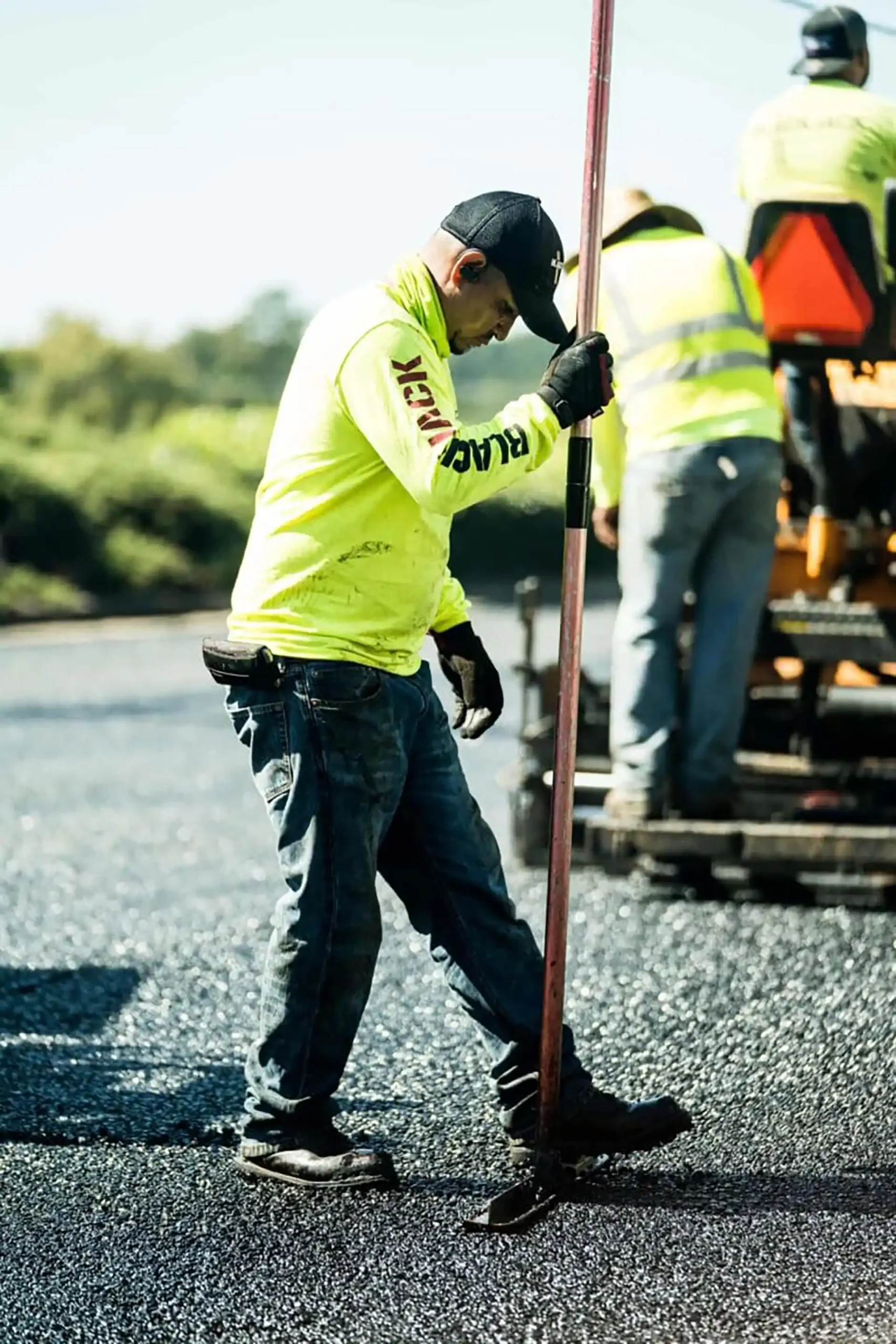 Crew performing asphalt paving on a street
