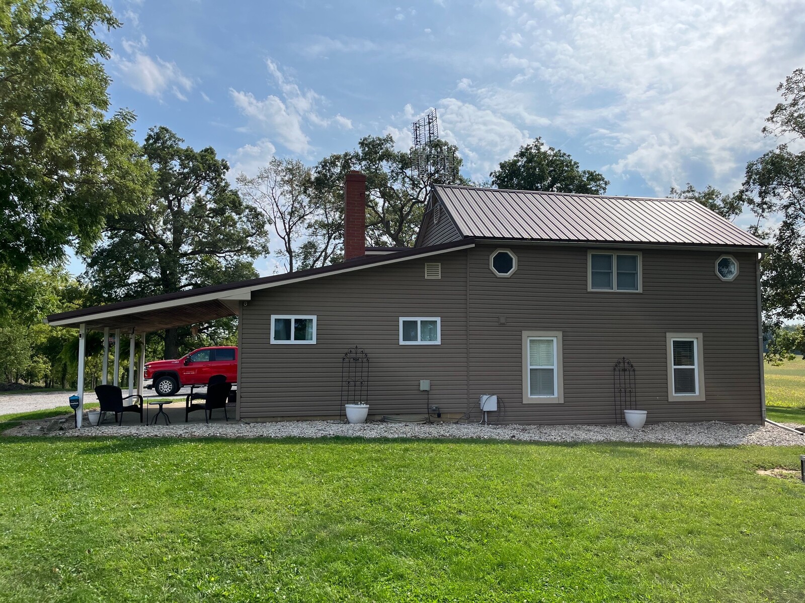 Rear view of a completed metal roofing system on a two-story residential property.