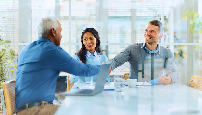 A wealth advisor shaking hands with a client.