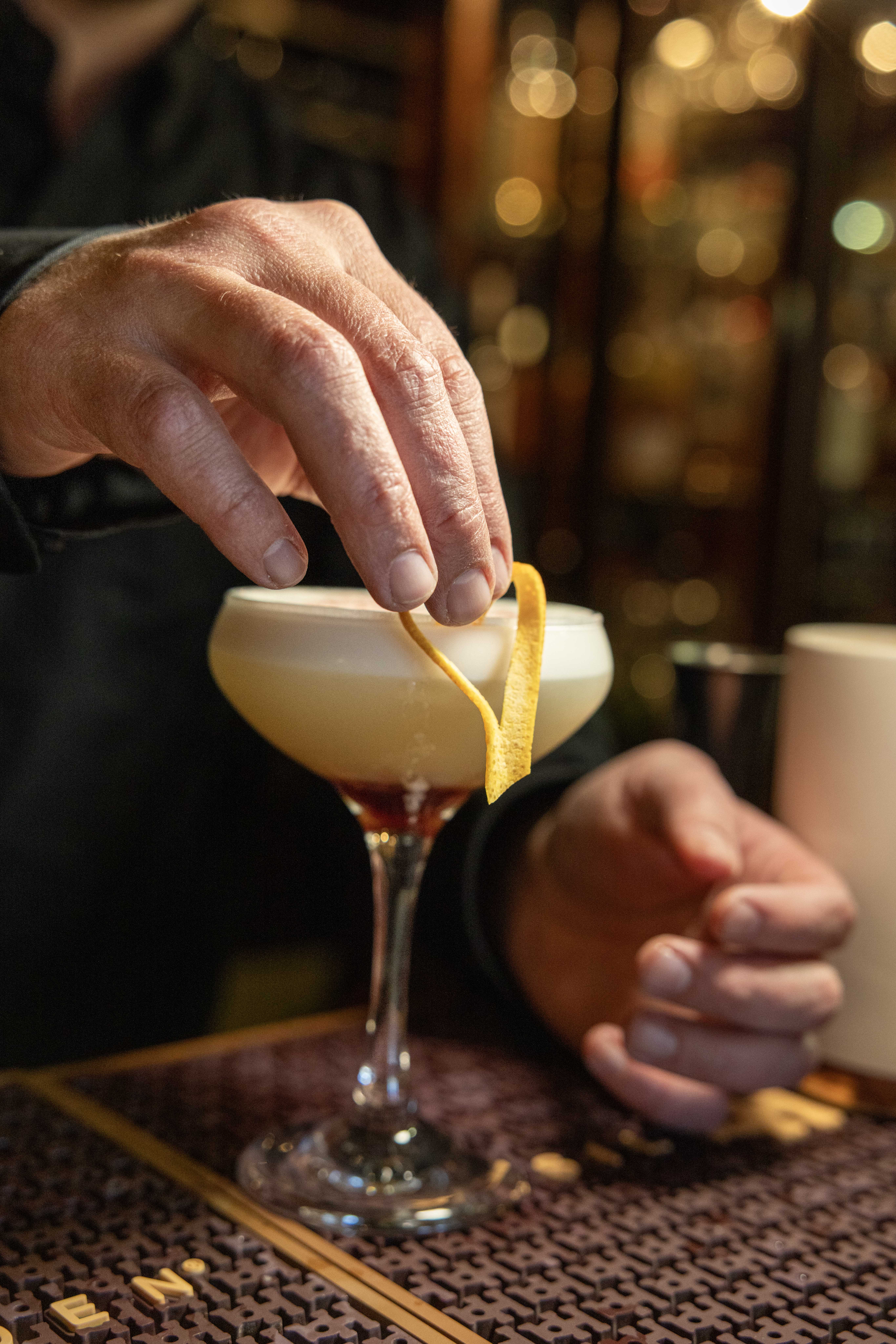 A handcrafted cocktail receives its finishing touch with a fresh citrus garnish at 313 Whiskey Bar i 