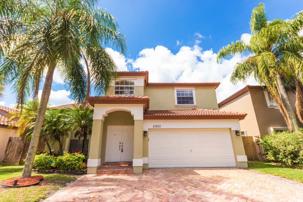 Beautiful home with large driveway and two-car garage at Invitation Homes South Florida.