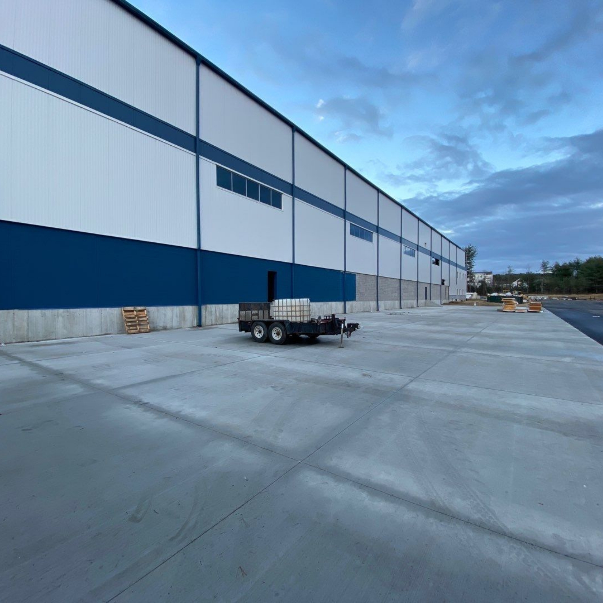 Warehouse exterior with a large parking area.