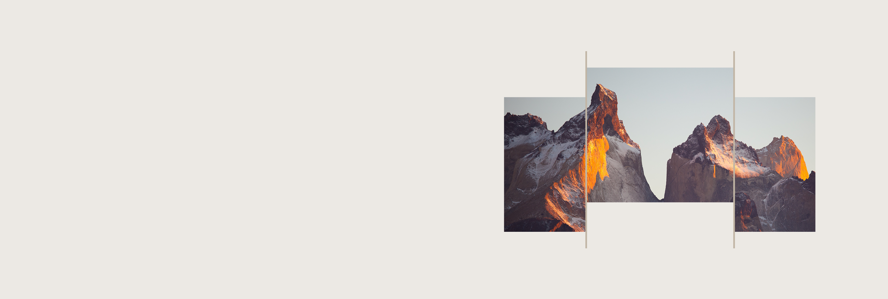 Sun reflecting off the rockface on the side of a rugged, snow-capped mountain.
