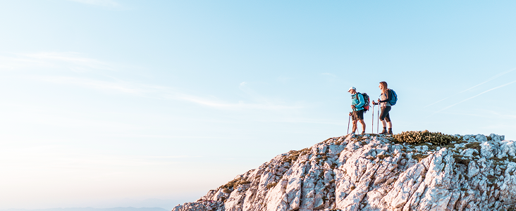 Two people hiking to the top of a mountain.