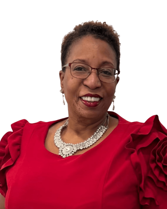 A headshot of a woman wearing glasses, a red dress, and a sparkly necklace. She is smiling broadly and has short, curly, dark hair. The background is a solid, dark blue-gray color.
