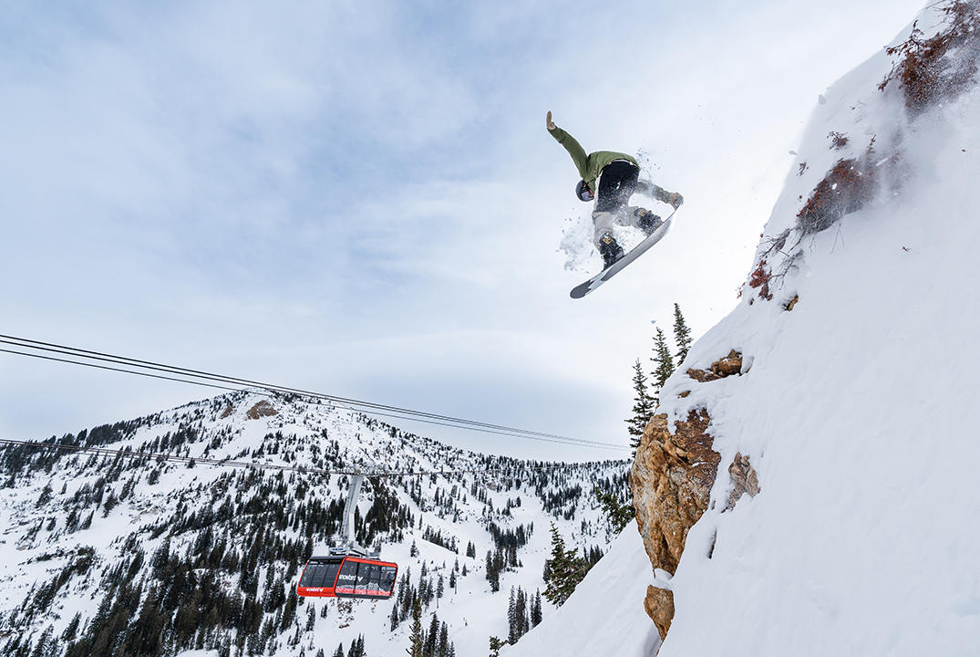 Snowboarder jumps off cliff above Snowbird tram