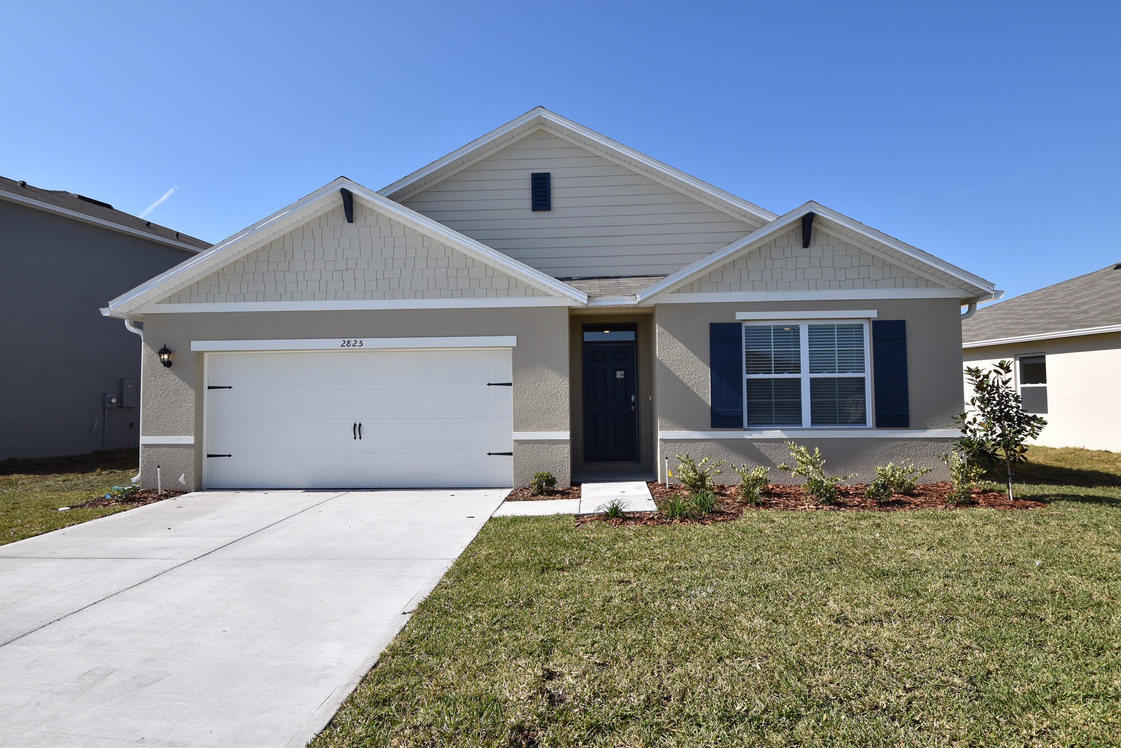 Front of home with driveway and two-care garage at Invitation Homes Tampa.