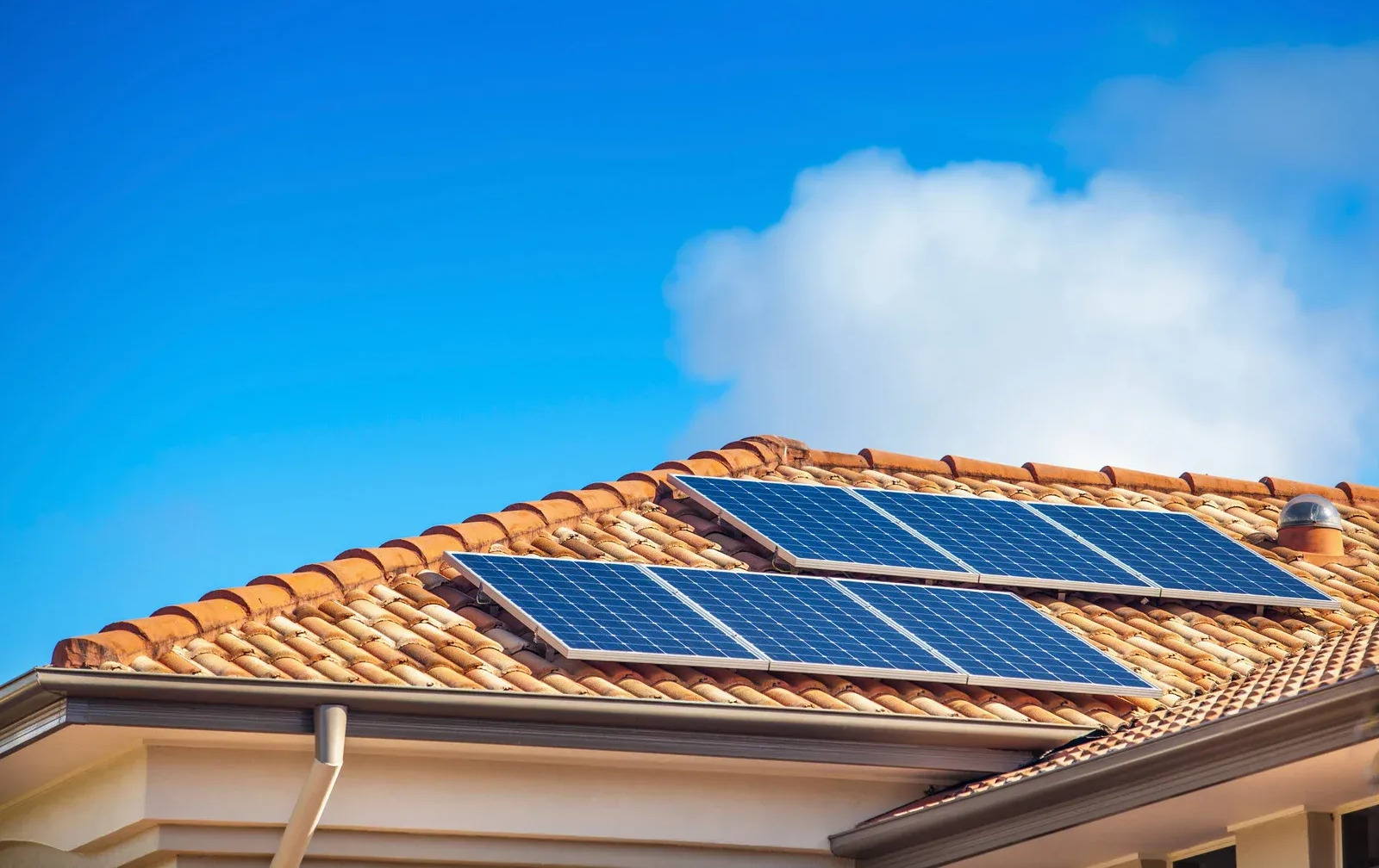 Residential clay tile roof equipped with solar panels, combining energy efficiency and roofing performance. The installation provides sustainable power generation while maintaining the home's visual appeal and value.
