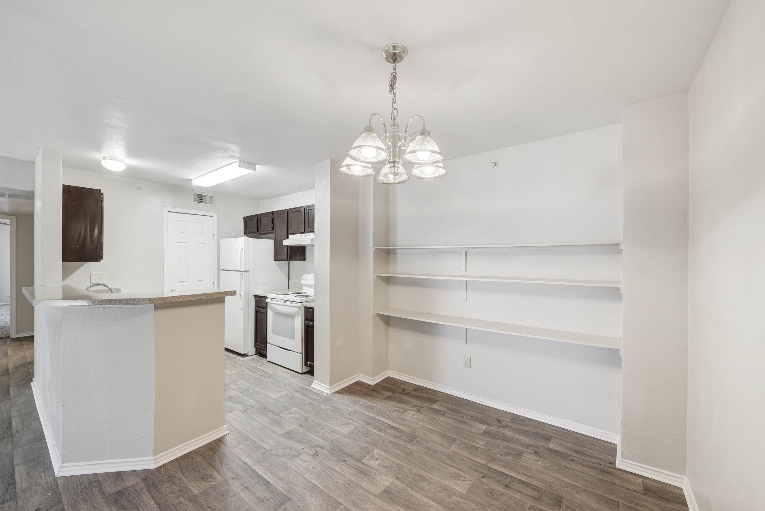A kitchen with a white counter and a white fridge.