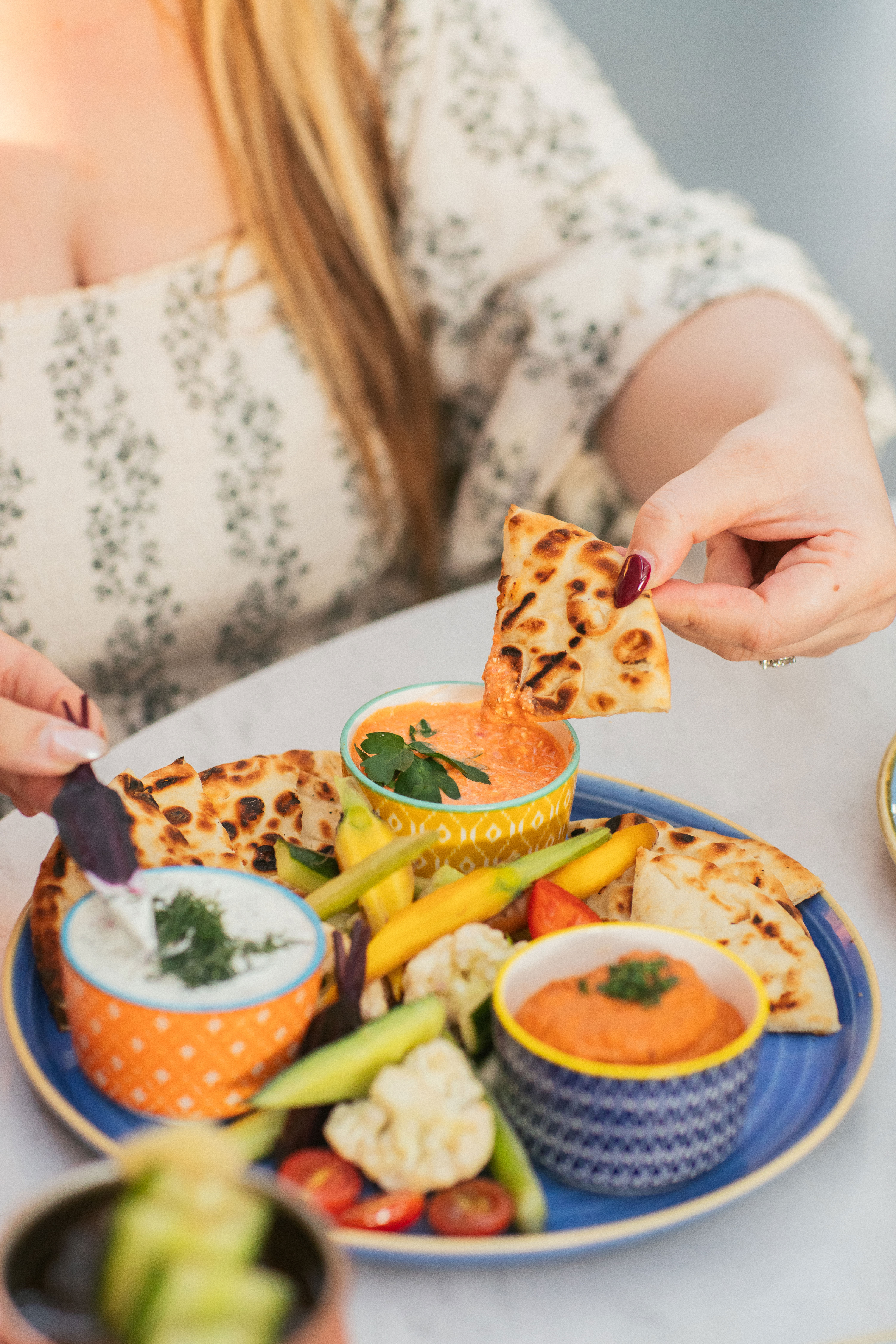 Mezze platter with roasted red pepper and feta, muhammara, tzatziki, with vegetable crudités and pit 