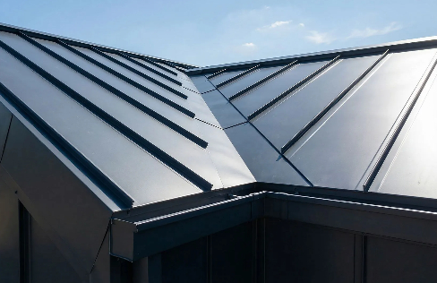 Close-up of a modern matte black standing seam metal roof valley, showing precision-bent metal panel 