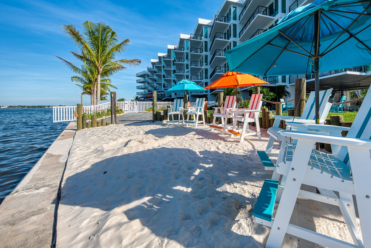 Private waterfront beach-style seating area with lounge chairs and marina views at FUSION Resort in Treasure Island, Florida.