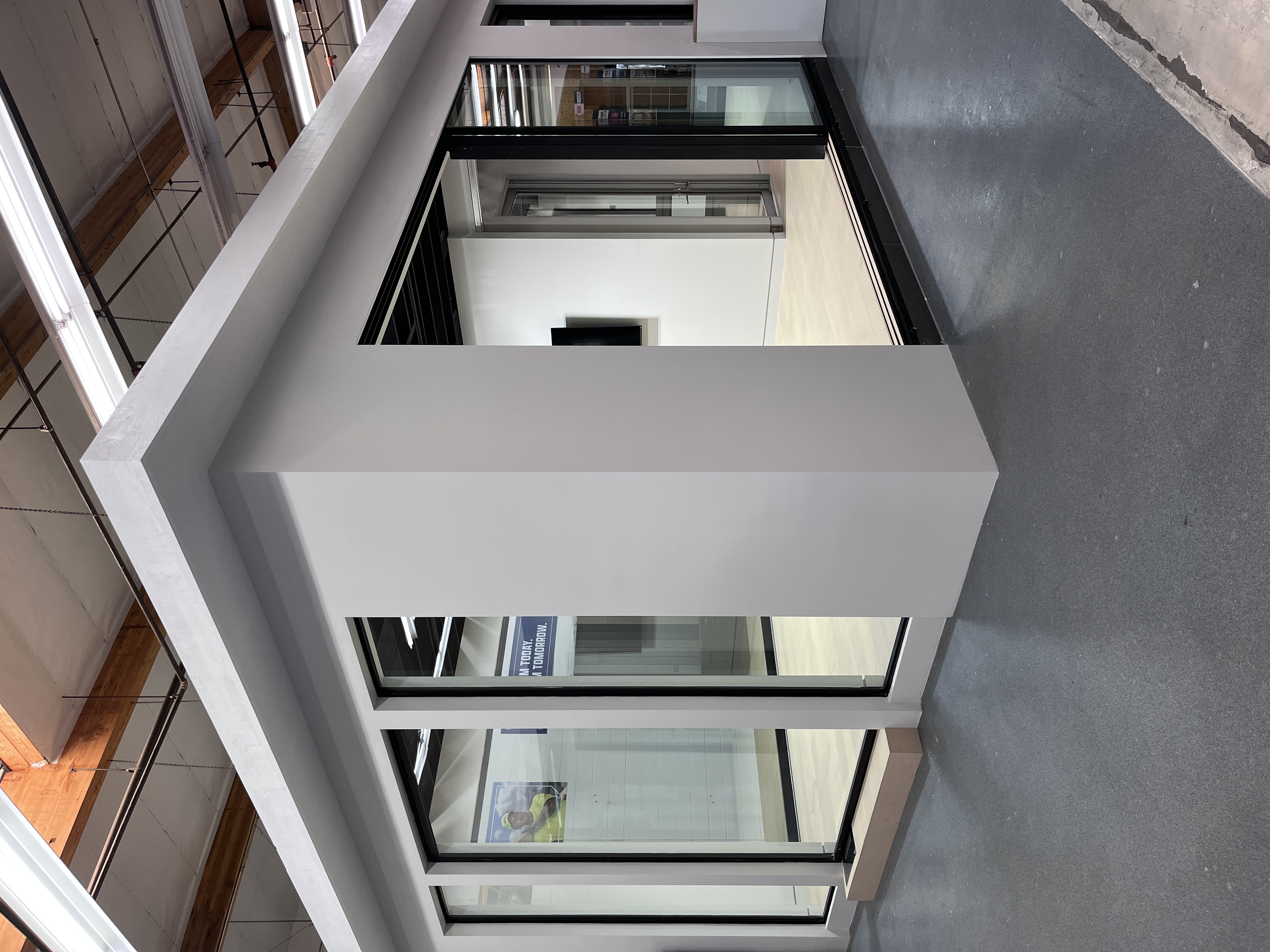 Interior showroom corner display at Builders FirstSource Thousand Oaks, CA, featuring large glass door and window units set into a mock building structure.