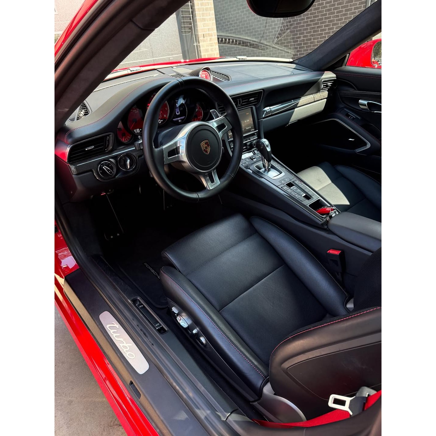 Freshly detailed Porsche interior showcasing clean leather seating, dashboard, center console, and i 