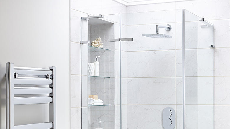 A glass hinged door shower enclosure surrounds a square waterfall shower in a white tiles bathroom