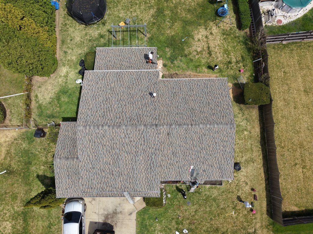 Aerial view of a completed residential roofing system featuring new shingles and clean installation. 