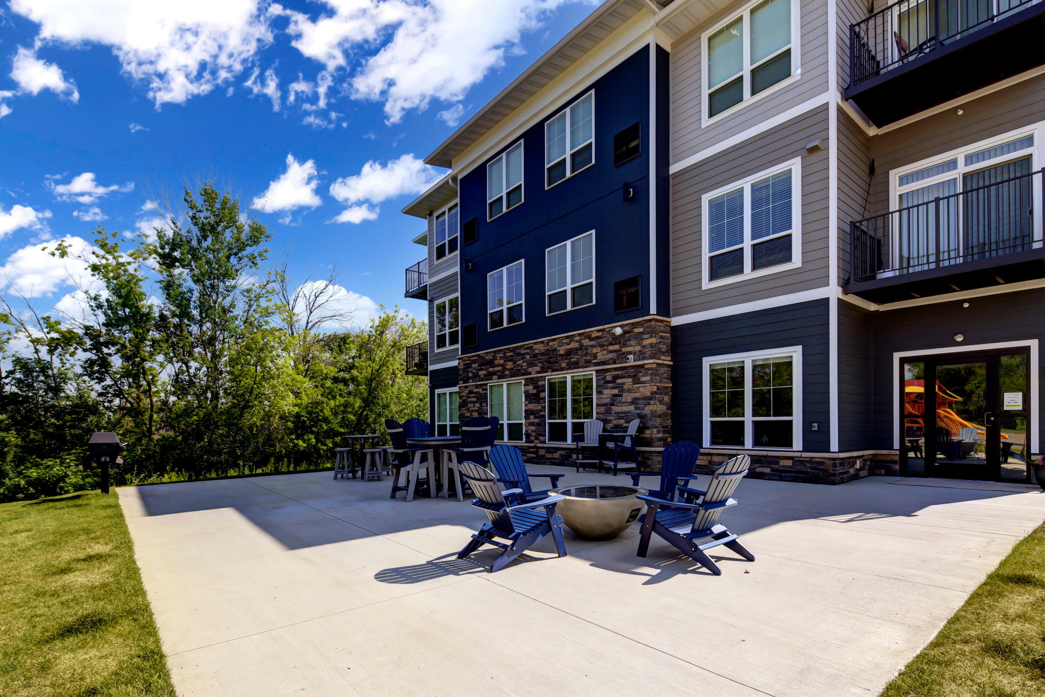 Outdoor Patio Area With Fire Pit & Adirondack Chairs