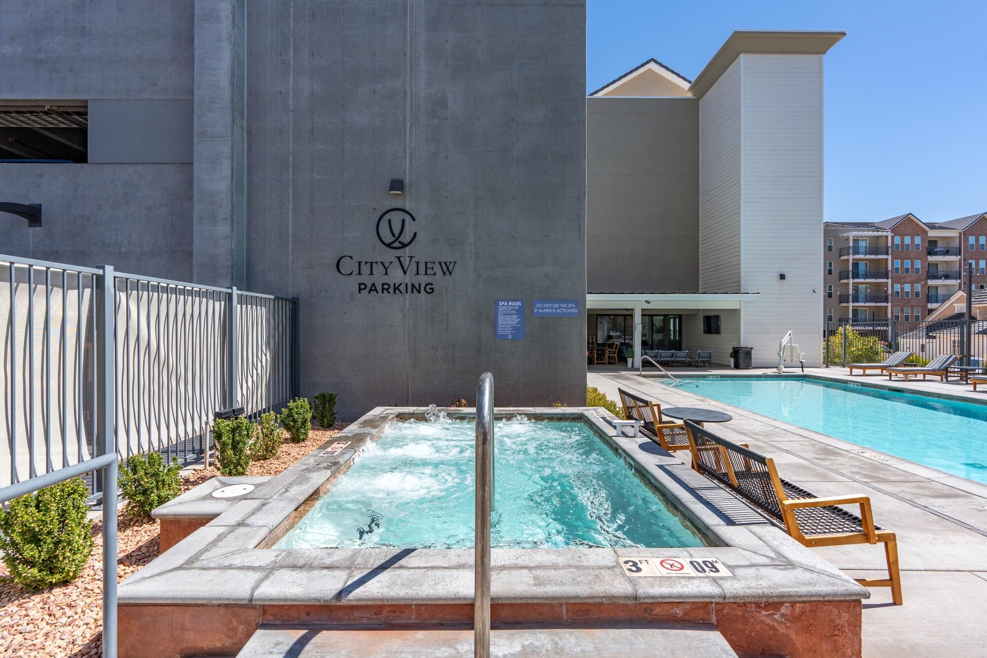 a swimming pool in front of a cityview parking building