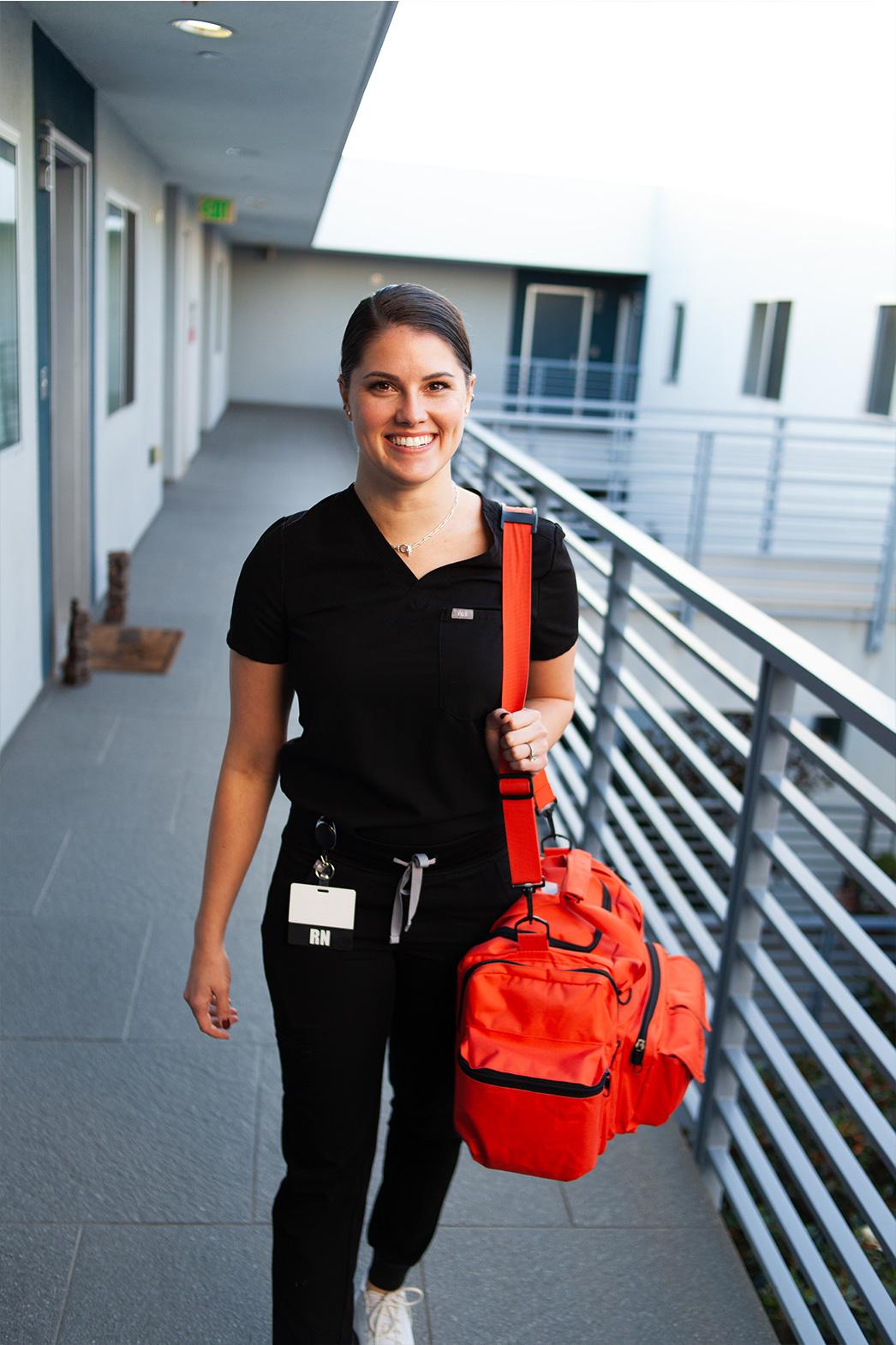 Smiling mobile IV nurse arriving for an in-home IV therapy session in Los Angeles.